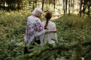 revocable living trust, image of a senior woman with arm around a younger female in the woods