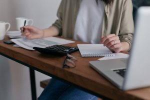 estate plan, image of woman working with a calculator at a table