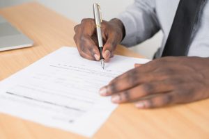 When Is an Estate Tax Return Due. image of man's hand signing a document